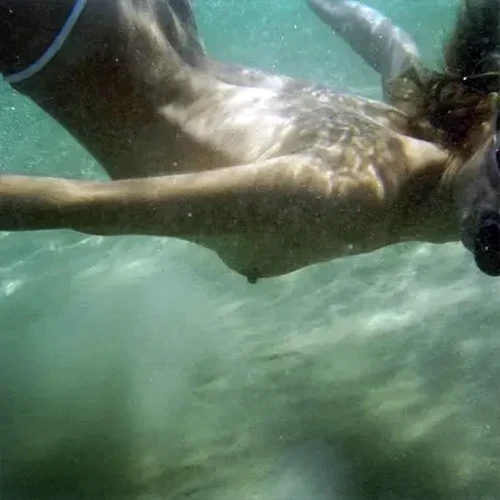 Nude woman swimming in ocean Nude woman swimming in ocean